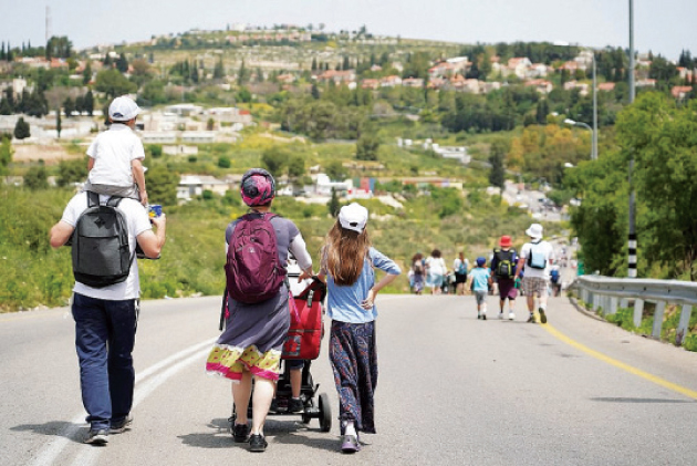 مستوطنون إسرائيليون يسيرون بالقرب من مستوطنة كيدوميم في الضفة الغربية المحتلة (أرشيفية)