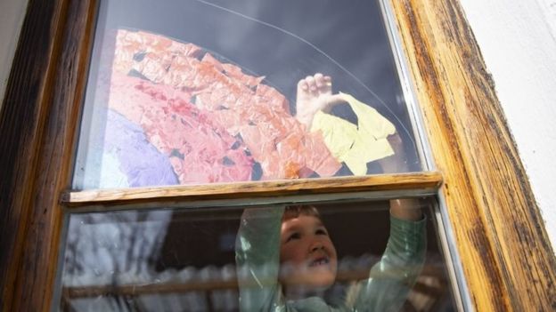 زين بعض الأطفال نوافذ بيوتهم برسوم لقوس قزح تعبيراً عن التفاؤل