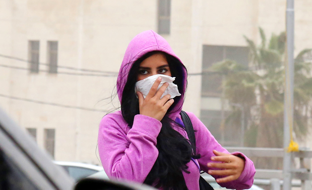 فتاة تضع منديلا على وجهها للوقاية من فيروس كورونا المستجد -(تصوير: أسامة الرفاعي)