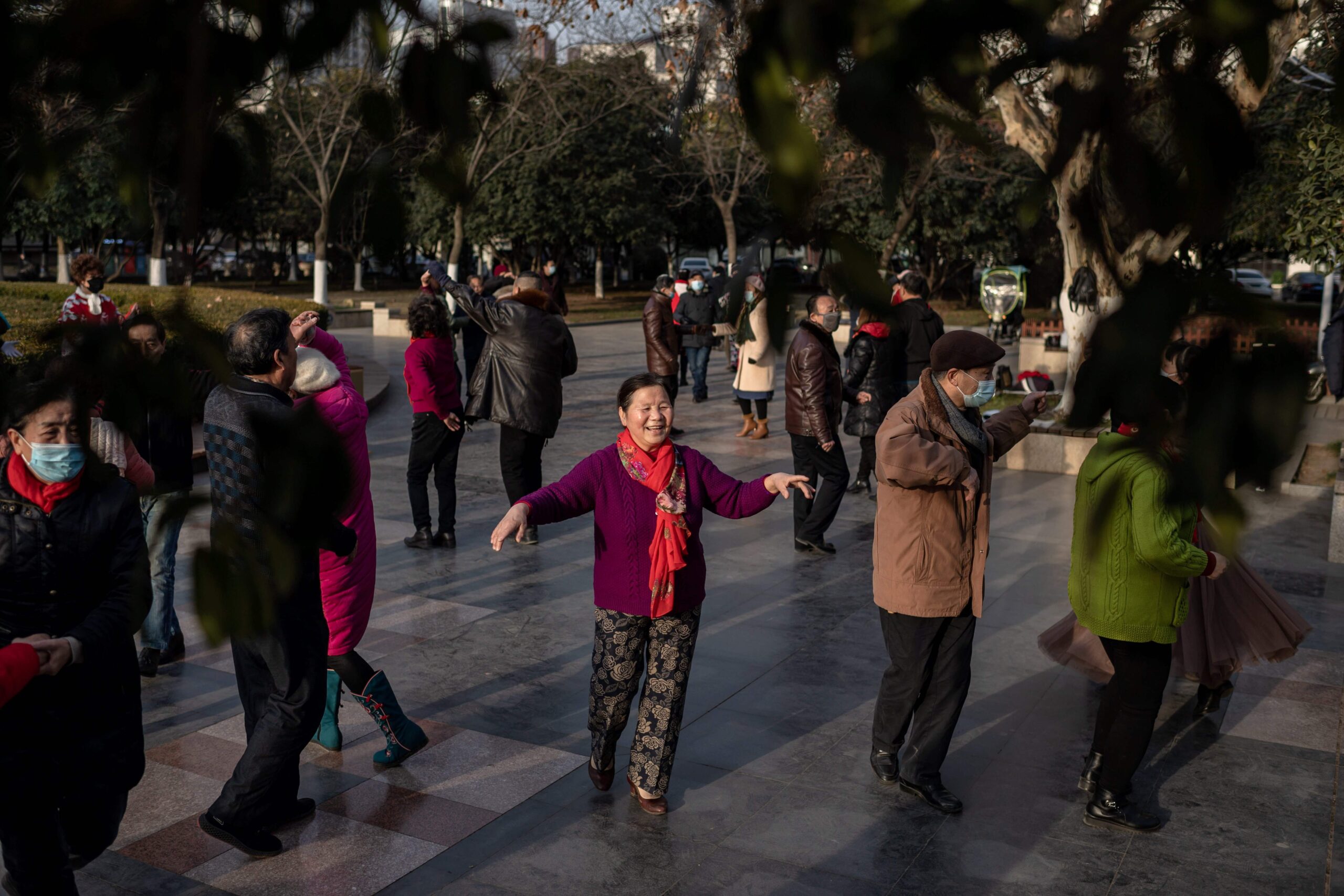المسنون يرقصون  في منطقة عامة على طول نهر يانغتسي في ووهان في الحادي عشر من يناير/كانون الثاني 2021، في حين تحيي المدينة الذكرى السنوية  عندما أكدت الصين  اول حالة وفاة بفيروس كوفيد-19 التاجي. ا ف ب